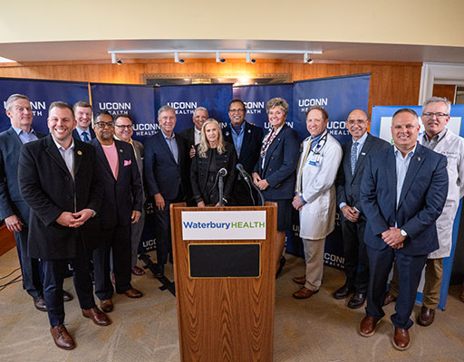 UConn Health and Waterbury HEALTH teams standing behind a podium