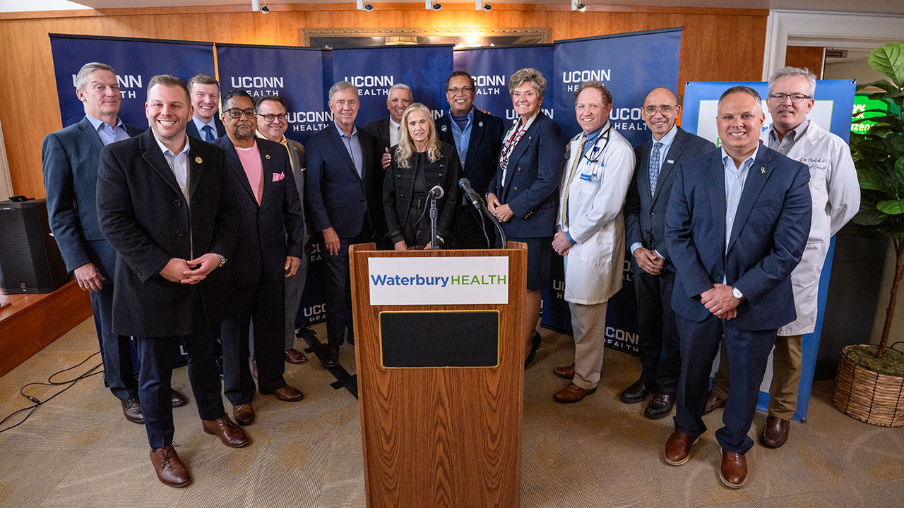 UConn Health and Waterbury HEALTH teams standing behind a podium