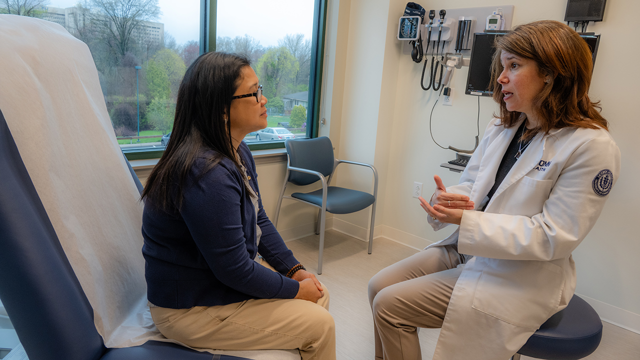 Karen Altomari-Nelson, RN, MSN, MSCN, meets with a patient in a medical office room