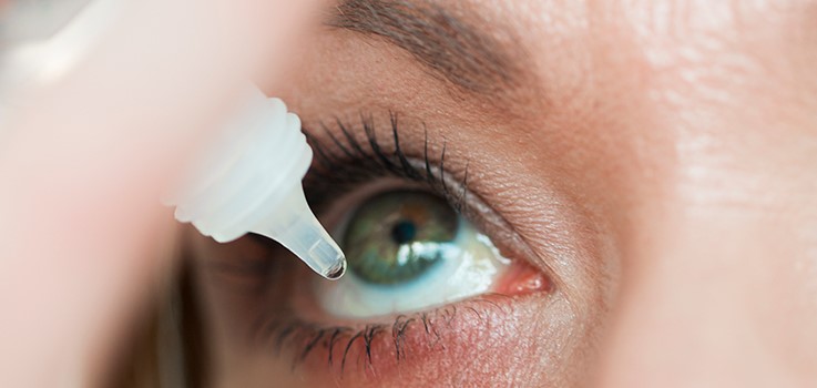 Woman putting in eye drops