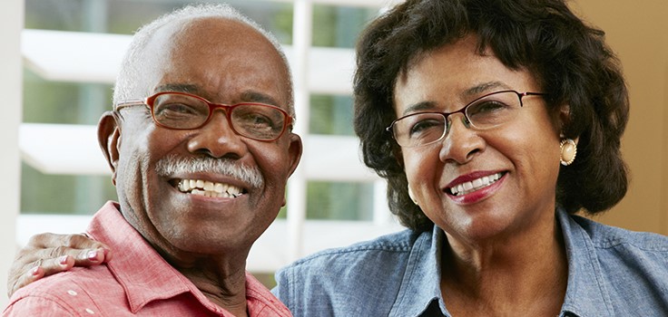 Senior husband and wife smiling at the viewer
