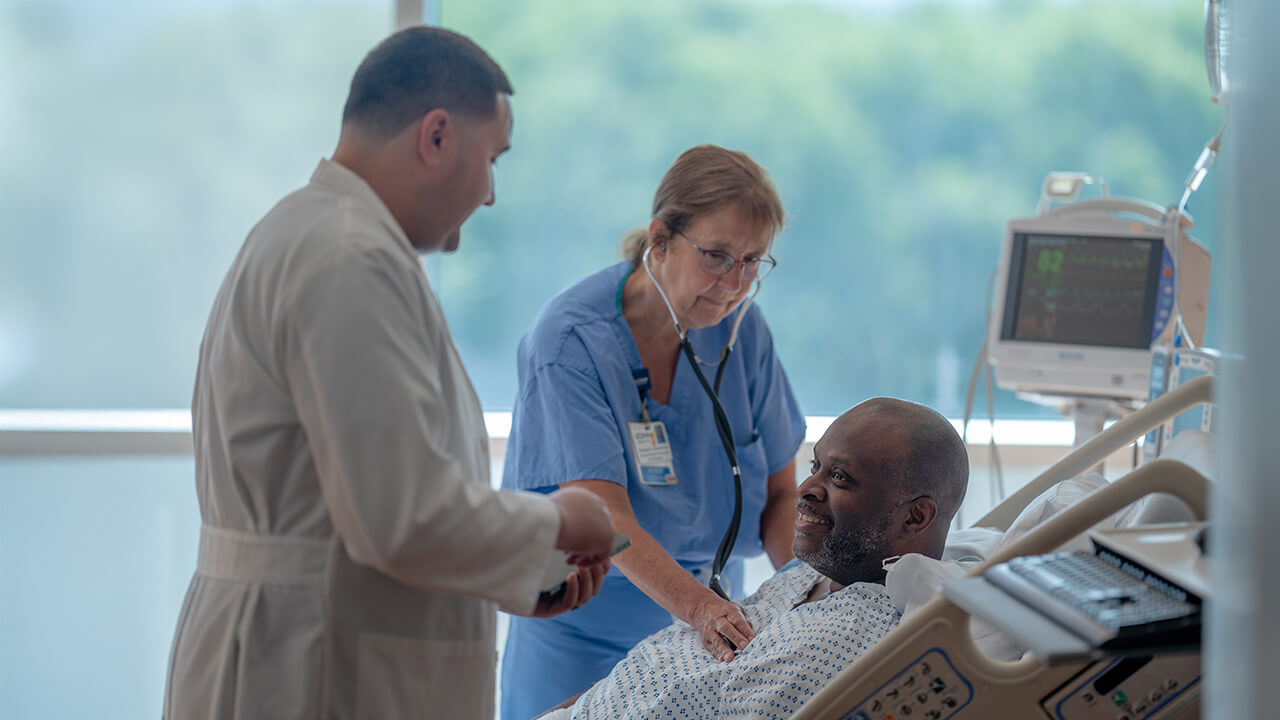 A nurse assists a patient in a hospital room, providing care and support during their recovery.