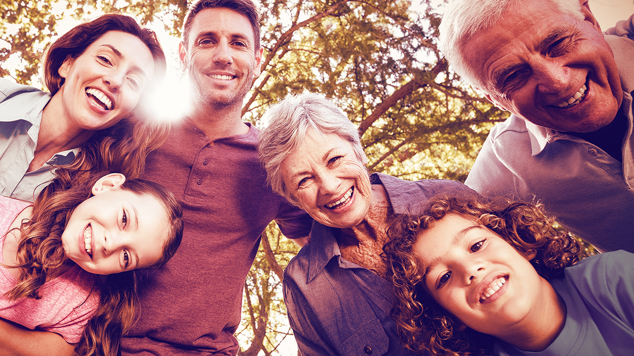 Men, women, and children smiling down into a camera