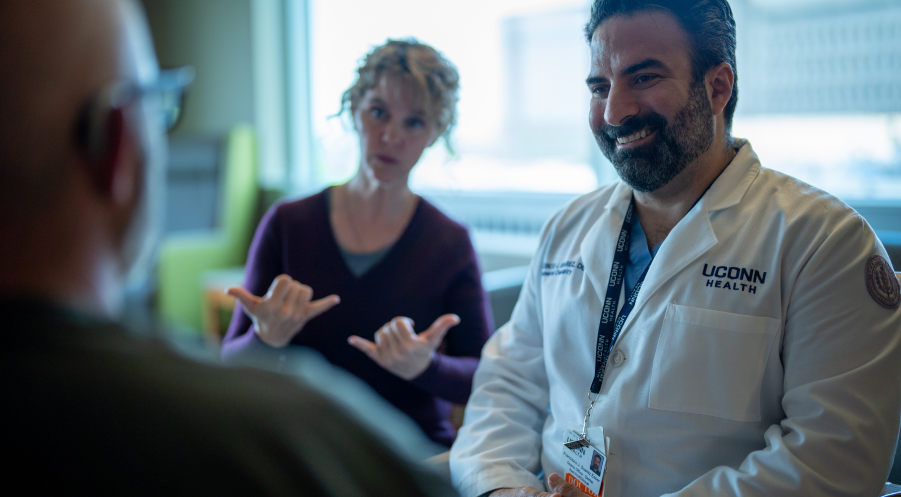 Doctor and sign language interpreter consulting with a patient