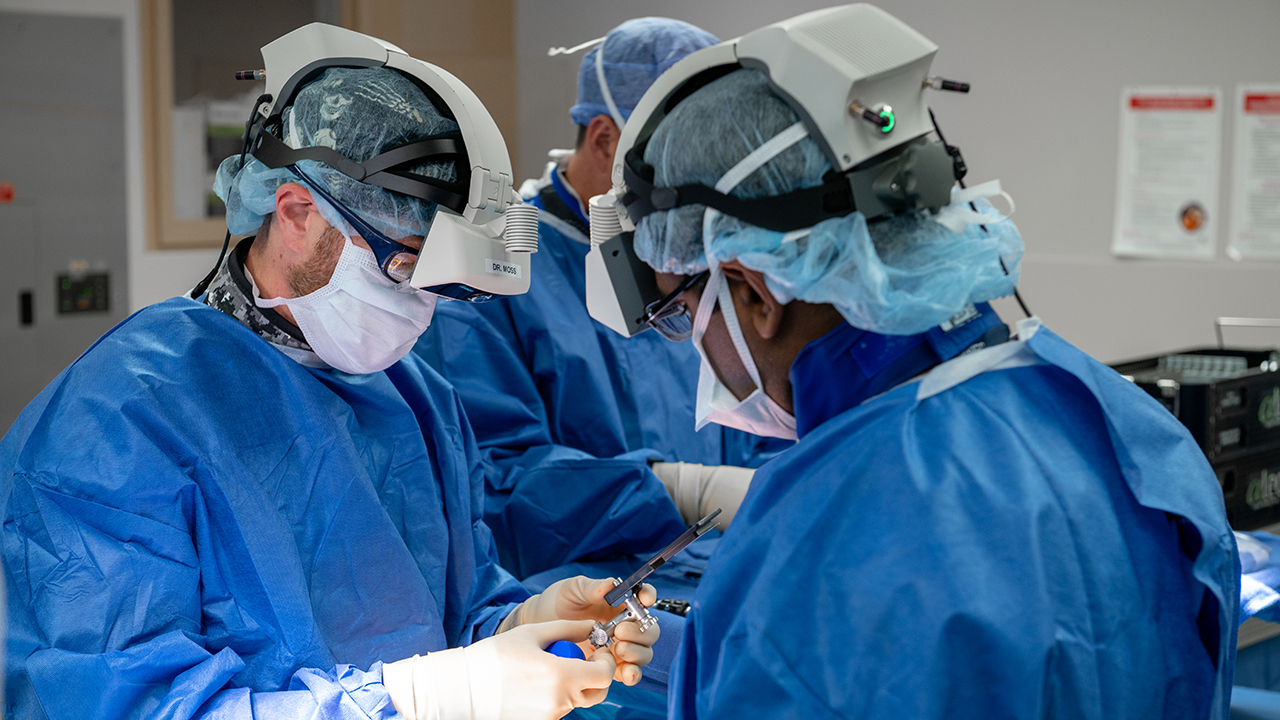 Dr. Isaac Moss performing spine surgery assisted by Tony Westhoff, RN, and spine fellow Dr. Chirag Chaudhary using augmented reality which provides real-time 3D imaging of the anatomy and projects it within the surgeon’s field of vision for a new level of precision and safety