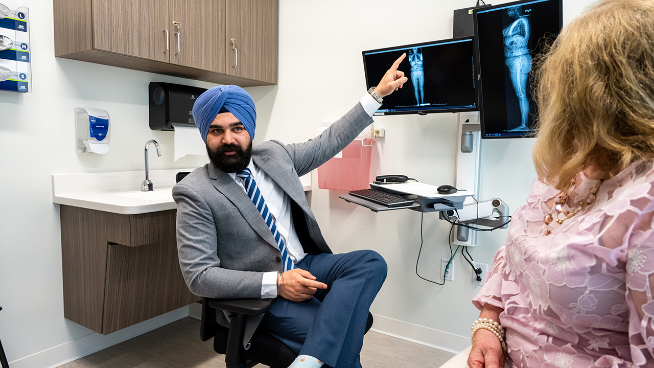 Hardeep Singh, MD, meets with a patient to go over her spine test results