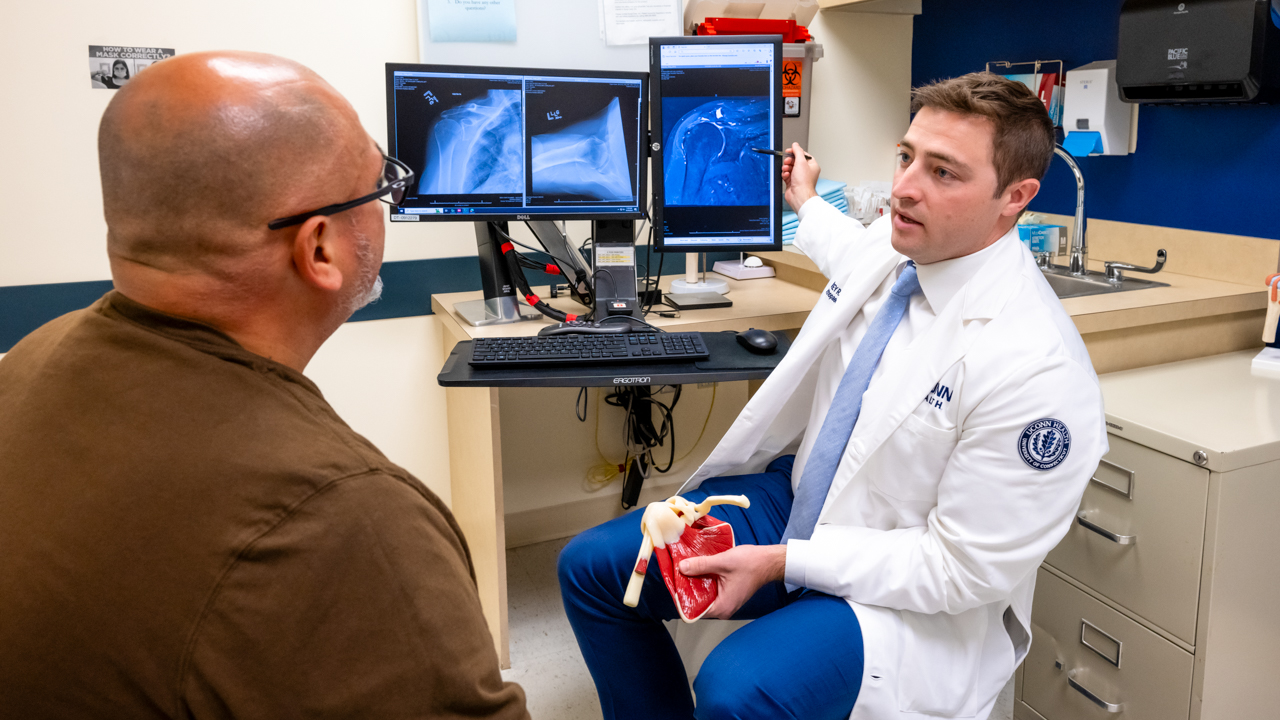 Dr. Corey Dwyer sitting across from a patient in an exam room