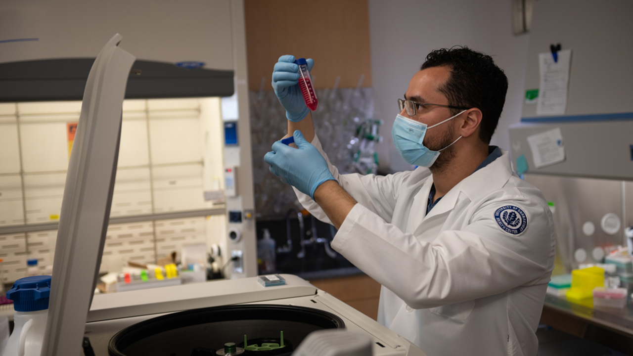 Rafael Ricci de Azevedo, PhD, postdoctoral fellow, holding up a test tube in a laboratory in the Department of Immunology